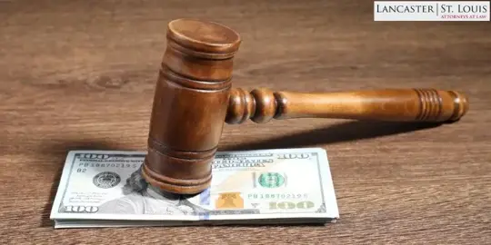 a gavel on top of a hundred dollar bill.